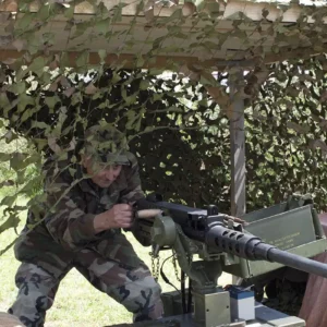 The oldest member of the Heathens reenactment group with a replica 50 caliber machine gun.
