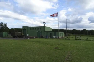 A view of the original museum building with the british flag flying in the foreground.