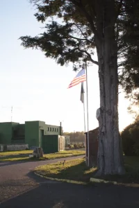 A view of the museum building at dusk with the British and American flags flying.