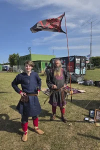Two members of the viking reenactment group with their emblem flying in the background.